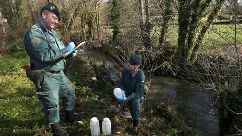 Agentes del Seprona tomando muestras del agua de un río en Barbanza