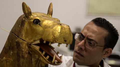 Un arqueólogo trabaja en una figura perteneciente a la cámara funeraria del rey