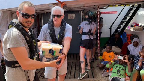 El actor Richard Gere (segundo por la izquierda) estuvo este viernes a bordo del Open Arms colaborando en el reparto de alimentos