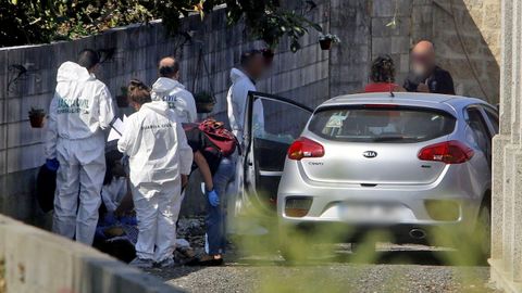 La polica cientfica trabaja sobre un cadver junto a un coche