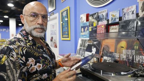 Carlos muestra un vinilo en su comercio Peggy Records, situado en Ourense
