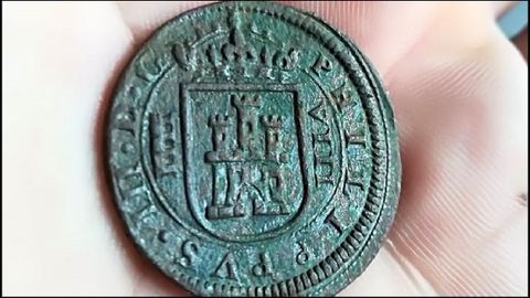 Una moneda de ocho maravedís hallada en el yacimiento de Cereixa. Fue acuñada en 1618, bajo el reinado de Felipe III. A la izquierda del escudo de Castilla está representado el acueducto de Segovia, lo que indica el origen de la pieza