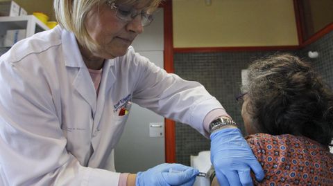 Una mujer recibe una vacuna contra la gripe en un centro de salud de Lugo en la campaña del 2016