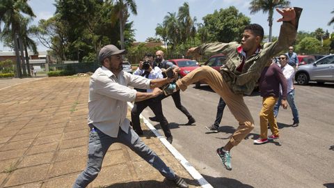 Un partidario de Maduro patea a un seguidor de   Guaid, tras la ocupacin de la Embajada de Venezuela en Brasilia