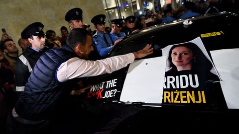 Un manifestante pega una foto de la periodista asesianda en el automóvil del ministro de Justicia,, durante una manifestación para pedir la renuncia del  Muscat
