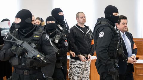 Agentes con pasamontañas y fusiles automáticos han trasladado a los acusados (en primer término el empresario Miroslav Marcek) a la sala del tribunal