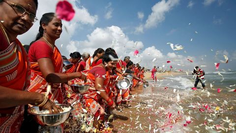 Un grupo de mujeres esparcen pétalos de flores en Bengala en homenaje a las víctimas