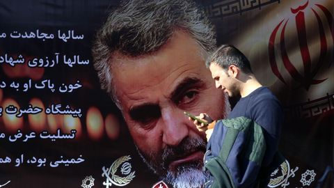Un hombre camina ante un enorme cartel con la imagen del general Soleimani en una calle de Tehern