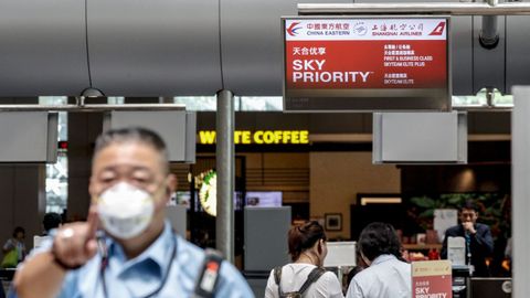 Un guardia de seguridad usa una máscara en el mostrador de facturación del Este de China en el aeropuerto de Changi en Singapur