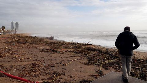 Una persona pasea este jueves por la playa de la Barceloneta, uno de los lugares más gravemente afectados por la borrasca Gloria