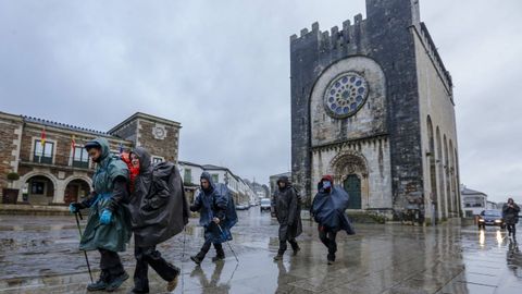 Peregrinos del Camino Francés ante la iglesia de San Xoán de Portomarín
