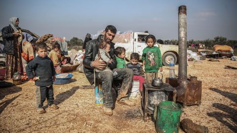 Un padre y su familia en un refugio improvisado creado para las familias que han huido de Saraqib y Sarmin