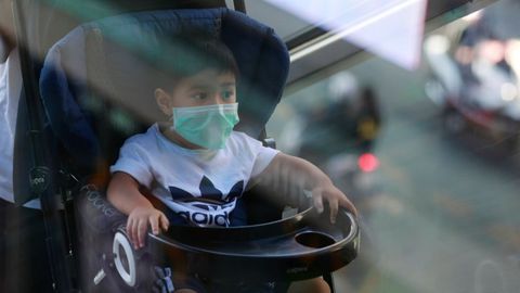 Imagen de un niño con mascarilla en Bangkok