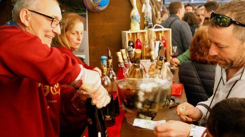 Un bodeguero descorcha una botella en uno de los puestos instalados en la feria