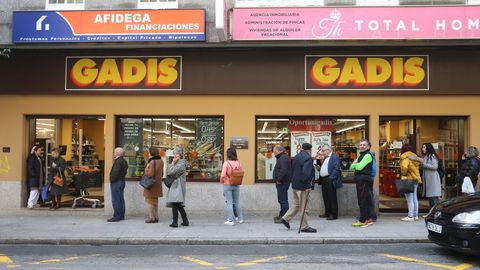 Colas manteniendo el metro recomendado de distancia de seguridad en un supermercado de Santiago