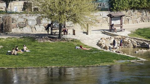 Gente tomando el sol en las termas de A Chavasqueira, Ourense