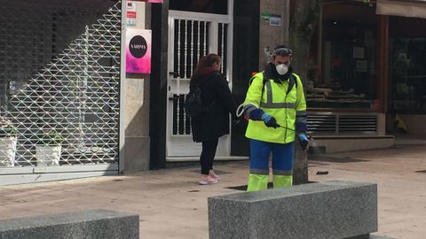 Trabajadores municipales desinfectando bancos, portales y otras zonas públicas de Ourense