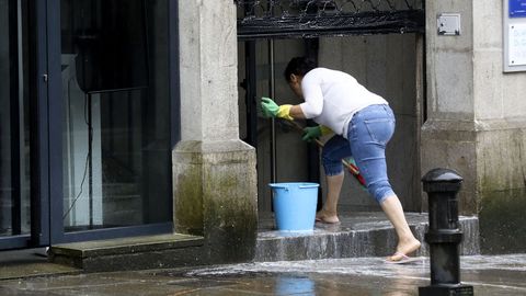 Una mujer limpia y desinfecta su local en Santiago