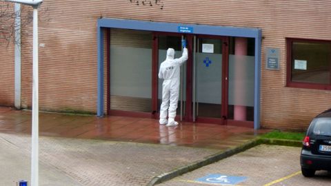 Un miembro de la UME desinfecta la puerta de Urgencias del centro de Laviada en Gijón