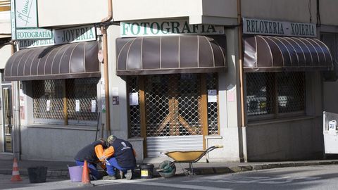 Dos operarios trabajan en una calle vacía de A Fonsagrada