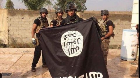 Militares iraques sostienen una bandera del Estado Islmico