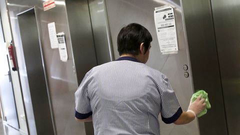 Una limpiadora desinfecta los ascensores de un centro de salud vigués