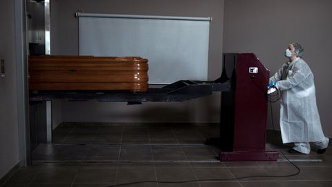 Una operaria transporta un atad con un fallecido por coronavirus para proceder a su incineracin en el interior de la capilla del crematorio-tanatorio As Burgas, en Ourense