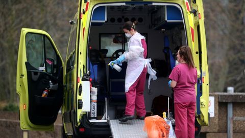 Personal medico se protege con máscaras en una ambulancia al lado del hosptial Santo Tomás de Londres