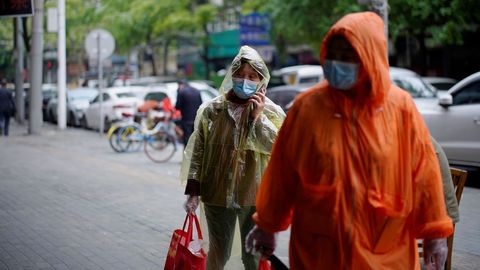 Dos personas con mascarilla en una calle de Wuhan
