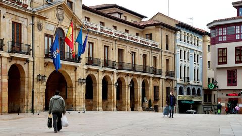Personas pasean este martes por la plaza de Ayuntamiento de Oviedo durante una nueva jornada marcada por el coronavirus.