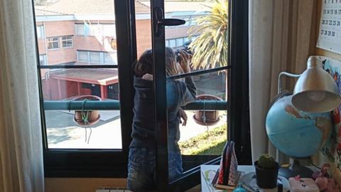 Una nia observa pjaros desde la ventana de su habitacin