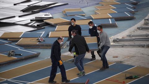 Varios operarios desmontando la pista de atletismo de Sabadell para montar el hospital de campaña