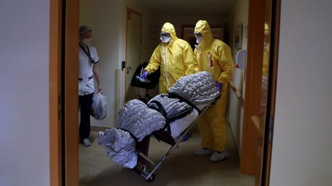 Trabajadores trasladan un cuerpo en una residencia de ancianos en Bruselas, Bélgica