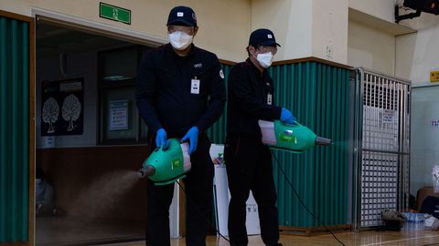 Trabajadores desinfectan un colegio electoral para la celebración de las elecciones generales en Seul, Corea
