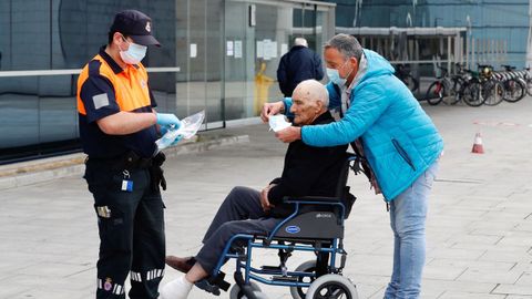Miembros de Protección Civil de Oviedo reparten mascarillas