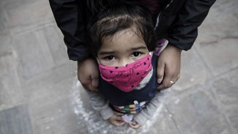 Una niña con su madre espera en Katmandú (Nepal) los artículos de ayuda distribuidos por la Sociedad Musulmana Newa, que ya ayudó a 50 familias de bajos ingresos confinadas. Nepal mantiene desde el 24 de marzo de 2020 las medidas de contención, en un esfuerzo por combatir la propagación del coronavirus