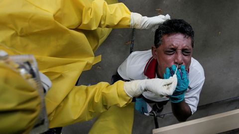 Un hombre reacciona cuando un funcionario de salud usa un hisopo para recolectar una muestra Sri Lanka