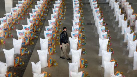 Un afgano, entre los sacos de comida preparados para donar a los más necesitados