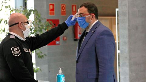 Un miembro de seguridad toma la temperatura al presidente del Gobierno de Asturias, Adrin Barbn, durante su visita este sbado a las instalaciones del Servicio de Emergencias del Principado (Sepa).