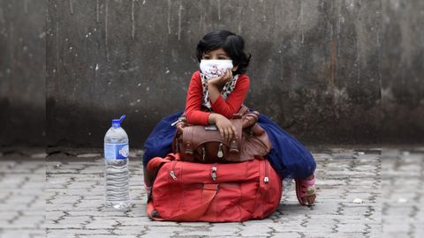 Una niña espera en una parada de autobús de la ciudad india de Guwahati