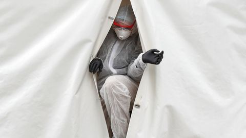 Un sanitario sale de un laboratorio móvil en el que realiza pruebas para detectar la enfermedad, en Rusia