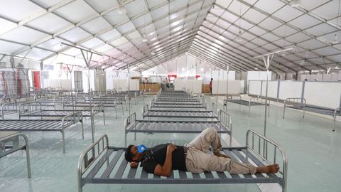En Dacca, un trabajador descansa durante la instalación de un nuevo hospital de campaña