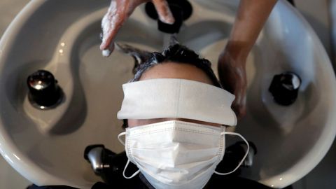 Una mujer acude a la peluquería ataviada con mascarilla