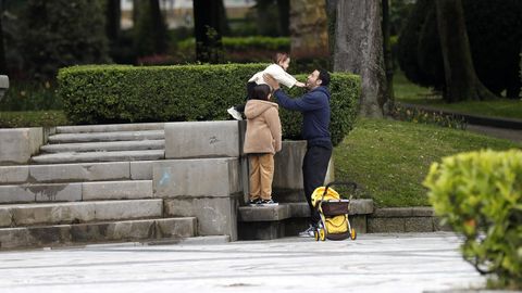 Un hombre juega con sus hijas en un parque del centro de Oviedo