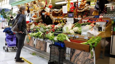 Varias personas realizan sus compras en una frutería en la plaza del Fontán de Oviedo