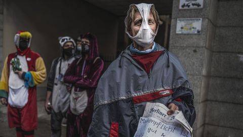 Un hombre en una protesta en Berln contra las restricciones, con una braga a modo de mascarilla y un cartel sobre la proteccin.