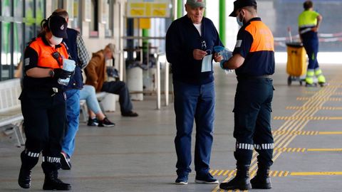 Miembros de proteccin civil reparten mascarillas este lunes en la estacin de autobuses de Oviedo