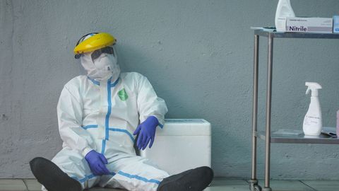 Un trabajador sanitario se toma un respiro ataviado con un traje de protección en Kuala Lumpur