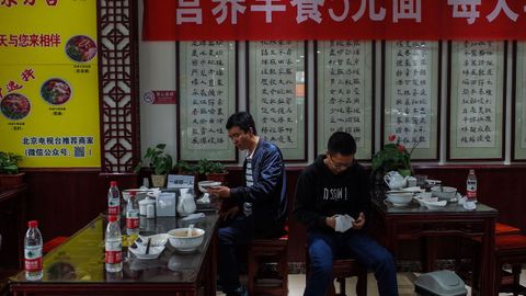 Dos clientes comen en un restaurante en China, el país donde se originó la pandemia