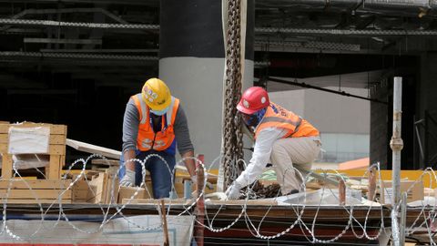 Trabajadores de la construcción usan mascarillas en un edificio en obras en Riad, Arabia Saudí